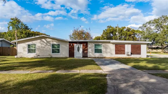 a view of a house with a big yard and large trees