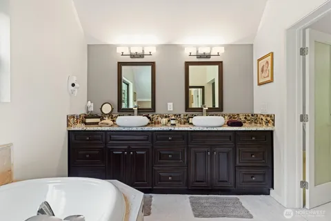 a bathroom with a double vanity sink and a bathtub