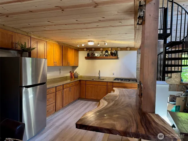 a kitchen with stainless steel appliances granite countertop a refrigerator a stove and a wooden floors