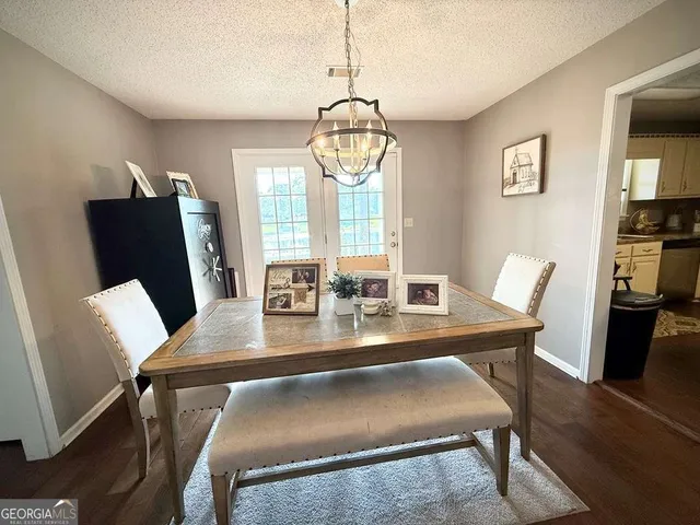 a dining room with furniture a chandelier and wooden floor
