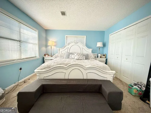 a bedroom with bed and wooden floor