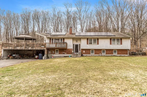 a view of a house with a yard and sitting area