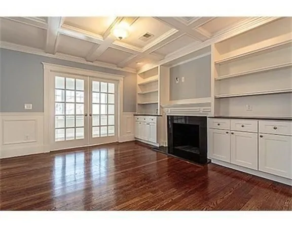 a view of empty room with wooden floor and fireplace