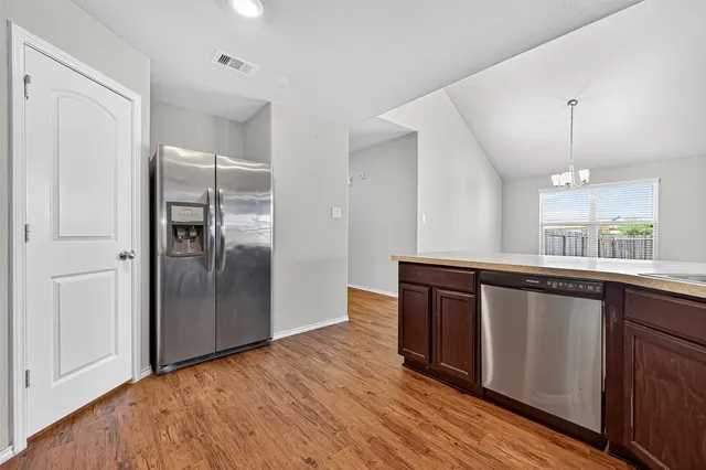 a kitchen with stainless steel appliances granite countertop a refrigerator and a sink