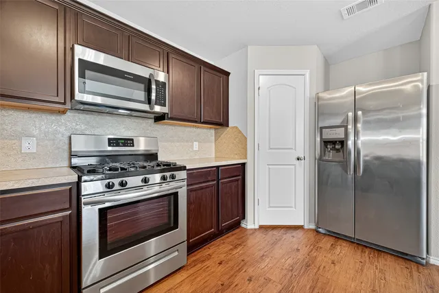 a kitchen with stainless steel appliances granite countertop a stove microwave and refrigerator