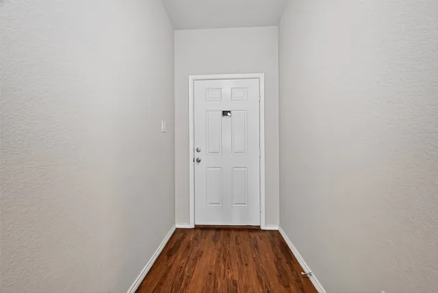 a view of a small space with wooden floor and a window