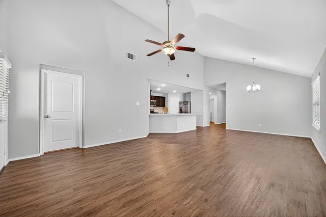 a view of a kitchen with wooden floor and a ceiling fan