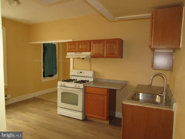 a kitchen with a stove top oven and sink