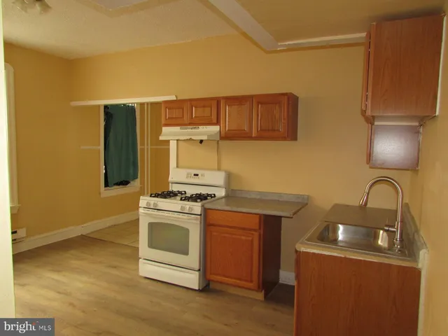a kitchen with a stove top oven and sink