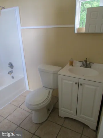 a white toilet sitting next to a bath tub