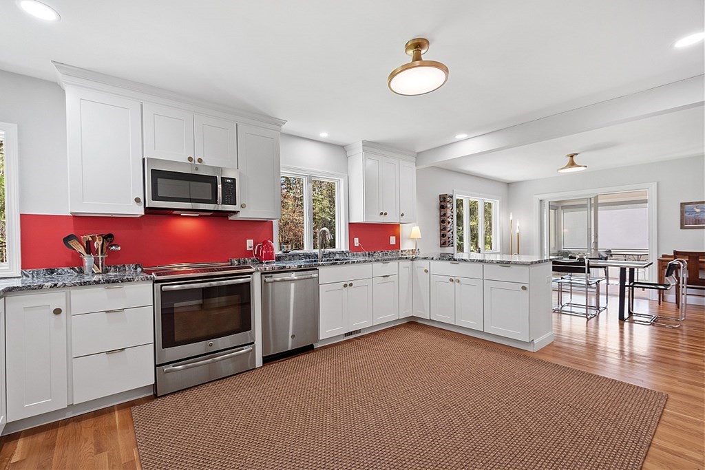 23 Nutting Road Groton, MA 01450 - Photo 7 of 42 a kitchen with stainless steel appliances granite countertop a stove top oven a sink dishwasher a dining table and chairs with wooden floor