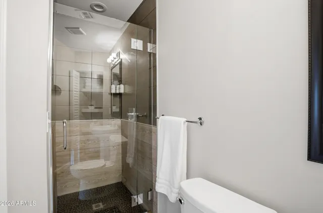 a bathroom with a toilet and a shower