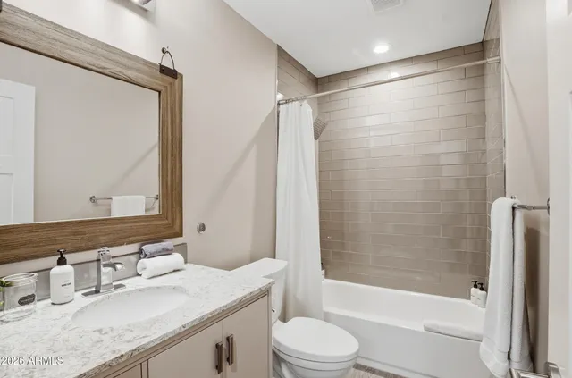 a bathroom with a granite countertop sink toilet and shower