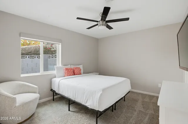 a bedroom with a bed a couch and a window