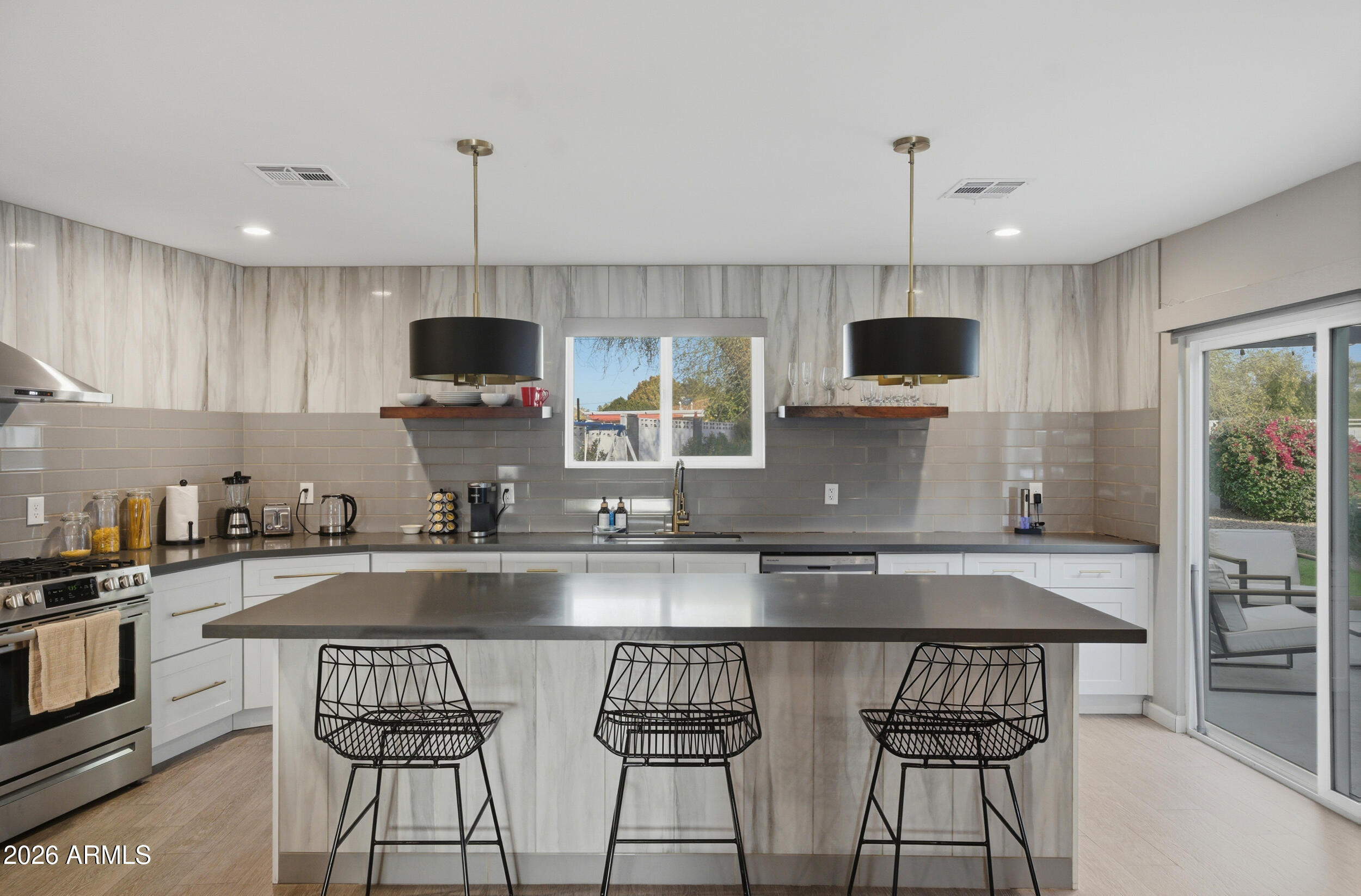 1134 East Colter Street Phoenix, AZ 85014 - Photo 6 of 27 a kitchen with kitchen island granite countertop a sink and a stove top oven with wooden floor