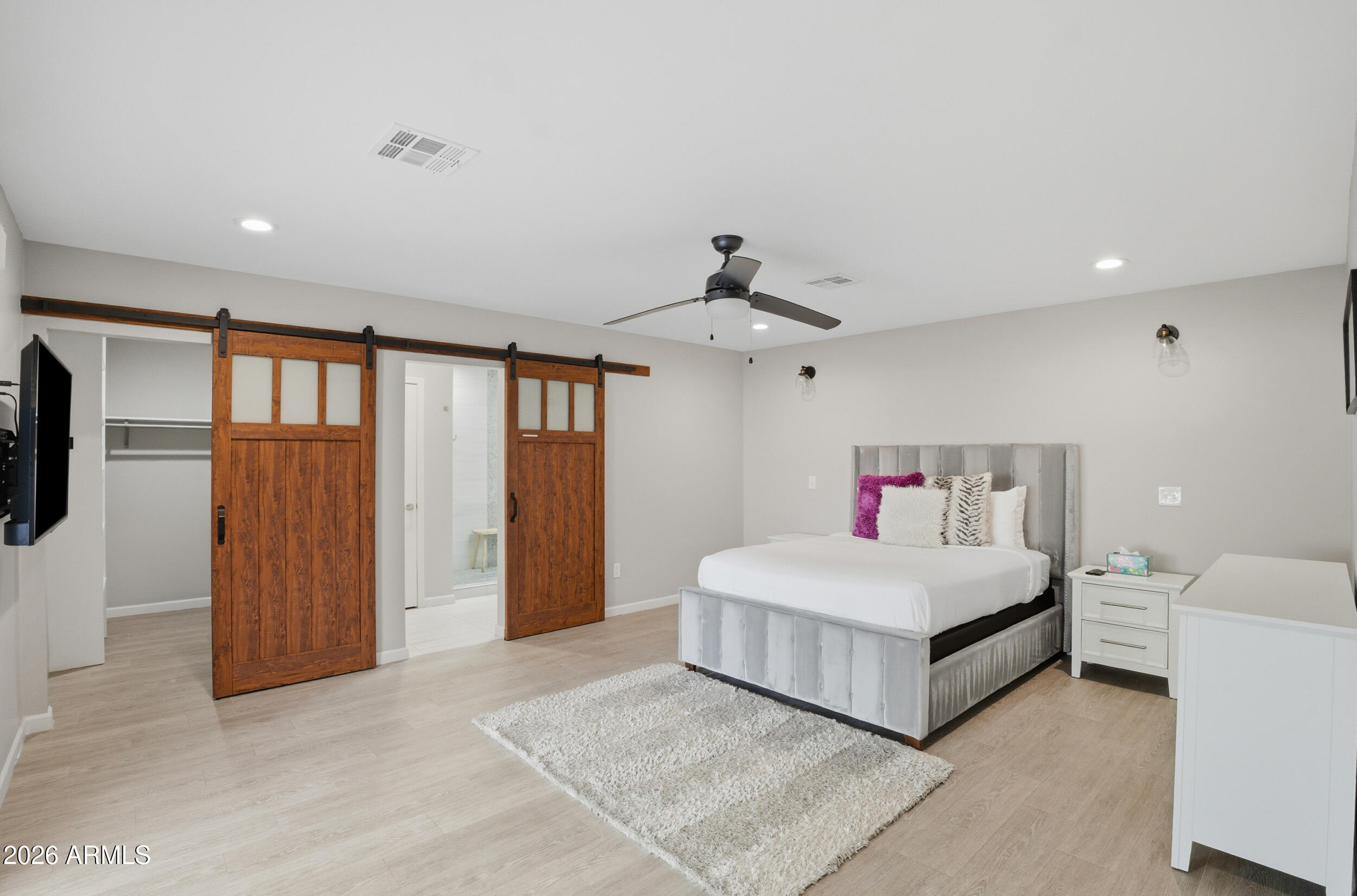 1134 East Colter Street Phoenix, AZ 85014 - Photo 9 of 27 a spacious bedroom with a large bed and a chandelier