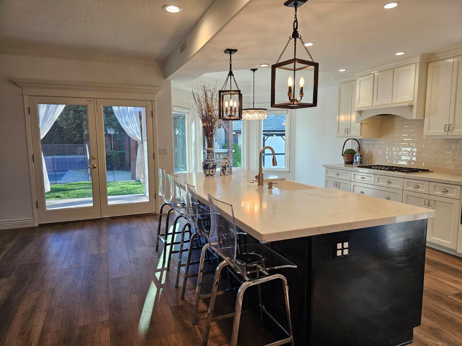 576 West Bedford Avenue Clovis, CA 93611 - Photo 18 of 79 a kitchen with stainless steel appliances granite countertop a stove a refrigerator a sink dishwasher a dining table and chairs with wooden floor