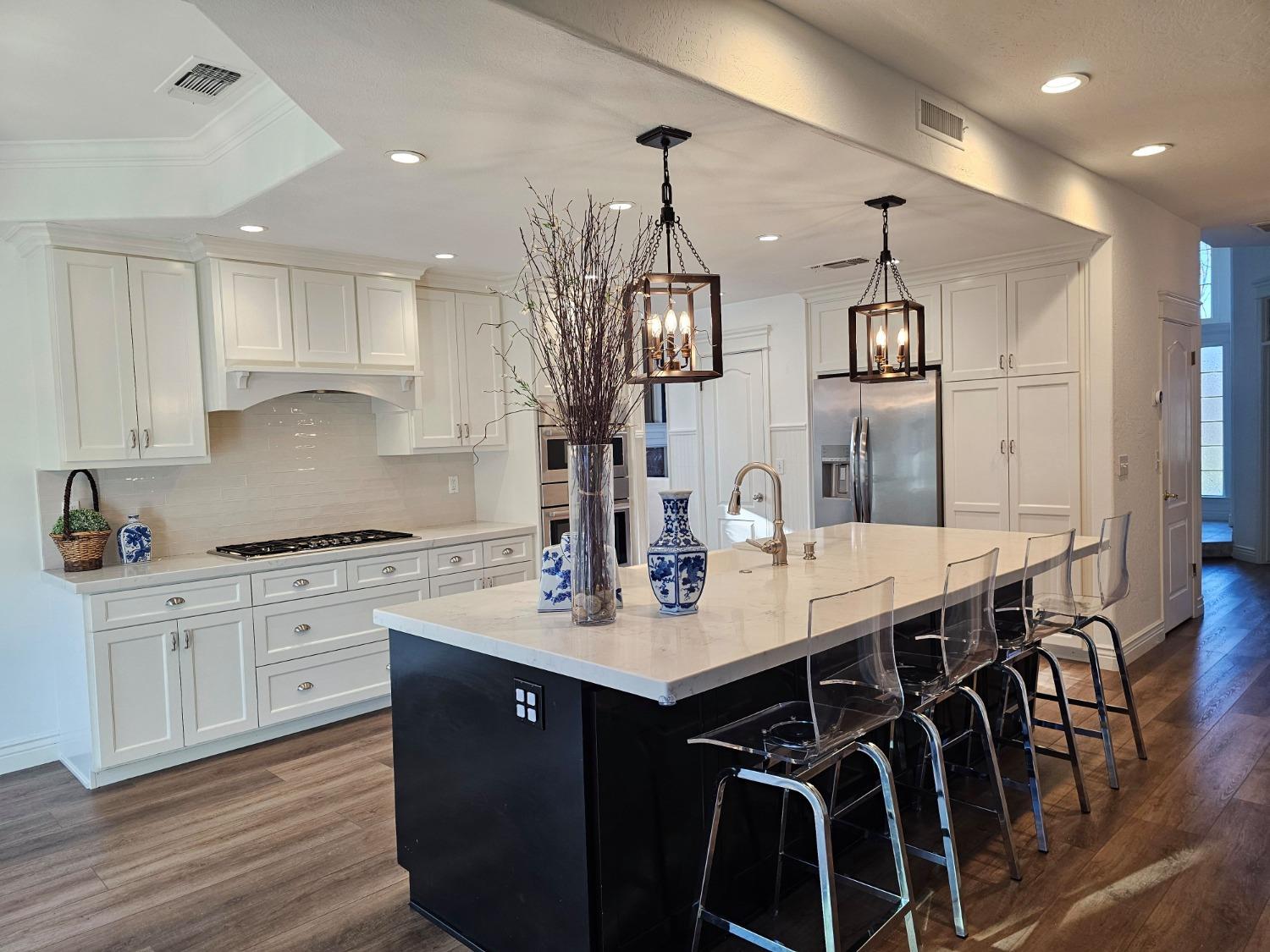 576 West Bedford Avenue Clovis, CA 93611 - Photo 26 of 79 a kitchen with stainless steel appliances kitchen island granite countertop a sink a stove a dining table and chairs