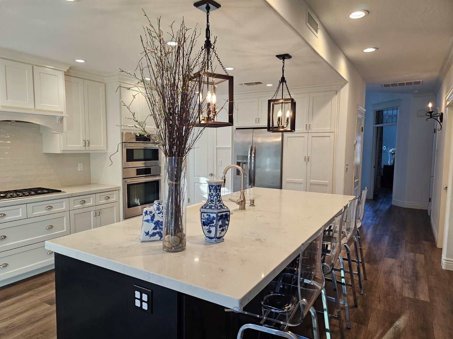576 West Bedford Avenue Clovis, CA 93611 - Photo 31 of 79 a kitchen with stainless steel appliances granite countertop a sink a stove and a wooden floors
