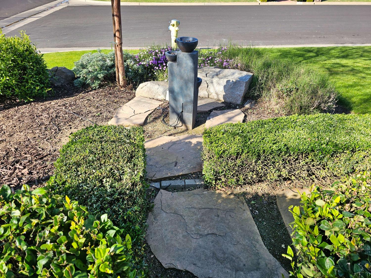 576 West Bedford Avenue Clovis, CA 93611 - Photo 4 of 79 a front view of a house with a yard and fountain