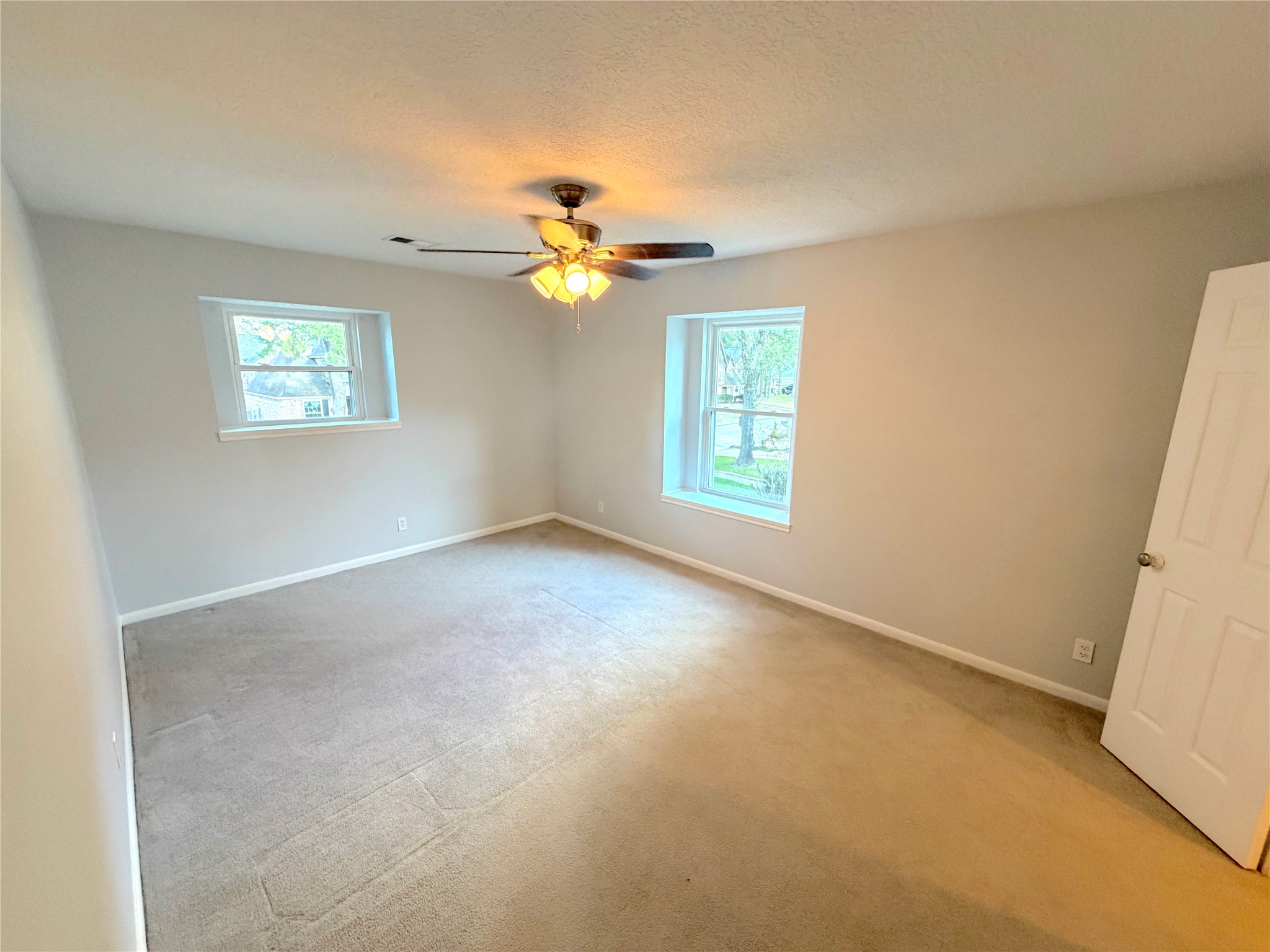 20723 Trellis Lane Houston, TX 77073 - Photo 22 of 29 an empty room with windows and chandelier fan
