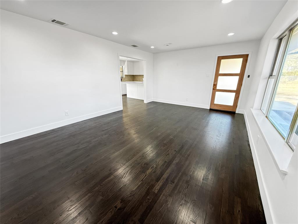 425 Chesier Road Lancaster, TX 75146 - Photo 9 of 15 an empty room with wooden floor and windows