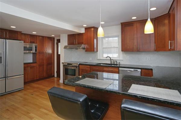69 Falmouth Road Newton, MA 02465 - Photo 4 of 5 a kitchen with stainless steel appliances granite countertop a sink wooden cabinets and a refrigerator