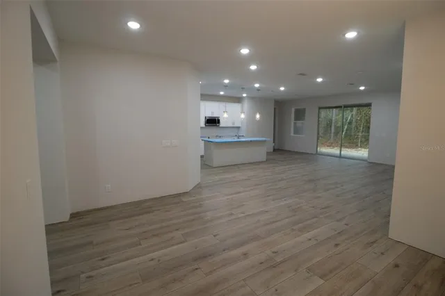 a view of kitchen with refrigerator sink and wooden floor
