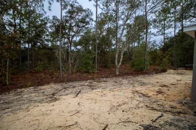 a backyard of a house with large trees and brick walls