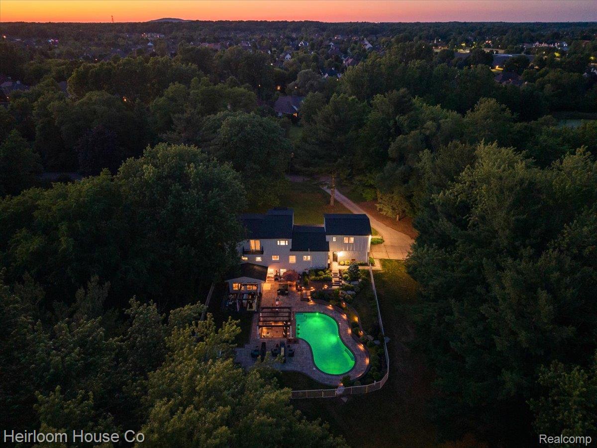 49001 Hanford Road Canton, MI 48187 - Photo 94 of 98 Private estate featuring a custom-shaped inground swimming pool with green illumination, surrounded by extensive paver patio areas