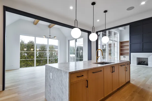 a kitchen with stainless steel appliances granite countertop cabinets a large island and a large window