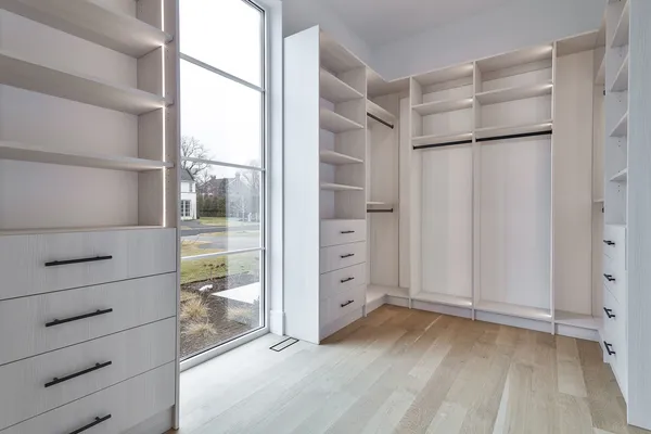a view of a hallway with wooden floor and windows