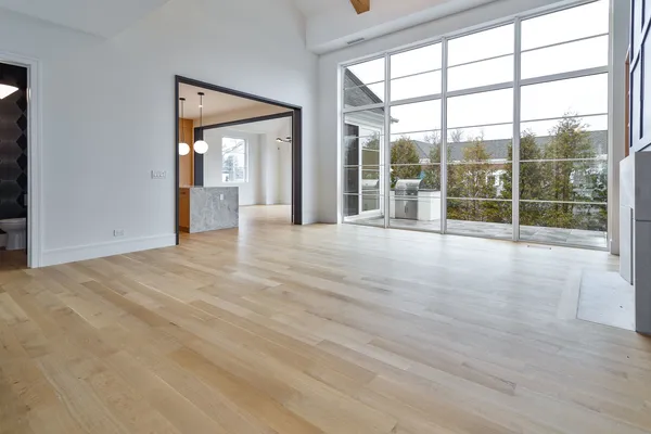 an empty room with wooden floor and windows