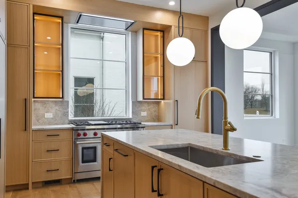 a kitchen with stainless steel appliances granite countertop a sink a stove and a window
