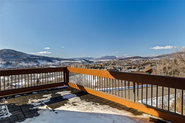 a living room with furniture a flat screen tv and kitchen view