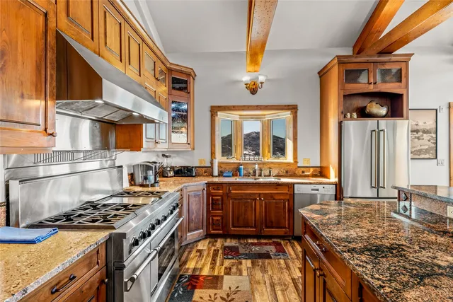 a kitchen with stainless steel appliances granite countertop a stove a sink and a microwave