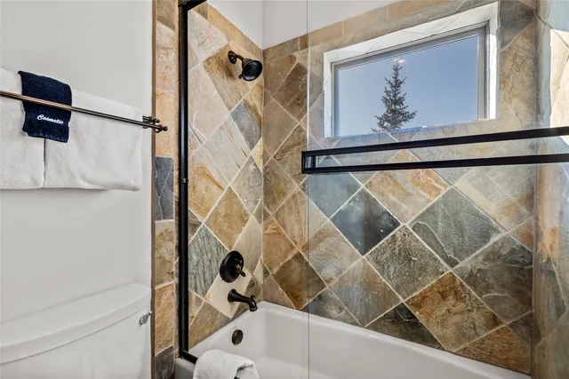 a bedroom with a bed a chandelier and a window