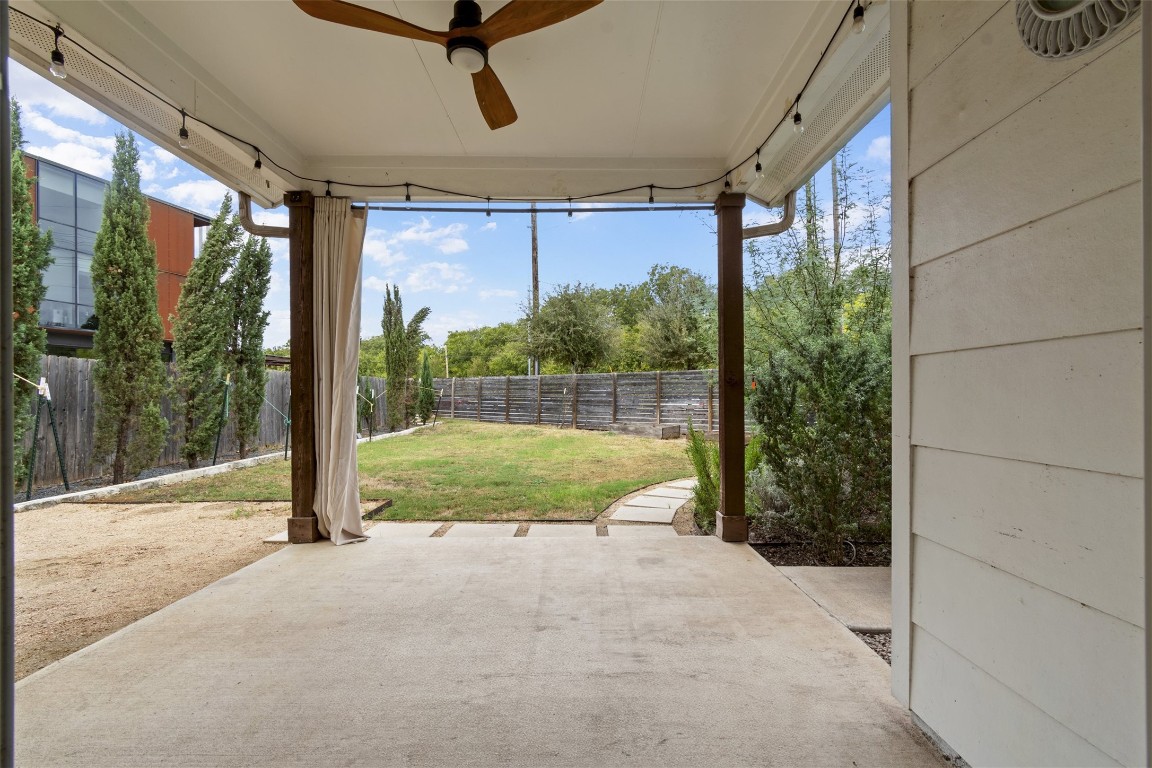 1145 Shady Lane, Unit 1A Austin, TX 78721 - Photo 13 of 25 Backyard & Covered Patio – Private fenced yard with lush greenery and a shaded covered patio, perfect for relaxing, entertaining, or enjoying Austin’s outdoor lifestyle year-round.