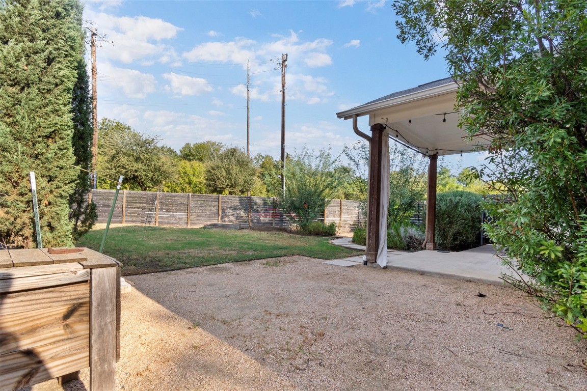 1145 Shady Lane, Unit 1A Austin, TX 78721 - Photo 14 of 25 Backyard & Covered Patio – Private fenced yard with lush greenery and a shaded covered patio, perfect for relaxing, entertaining, or enjoying Austin’s outdoor lifestyle year-round.