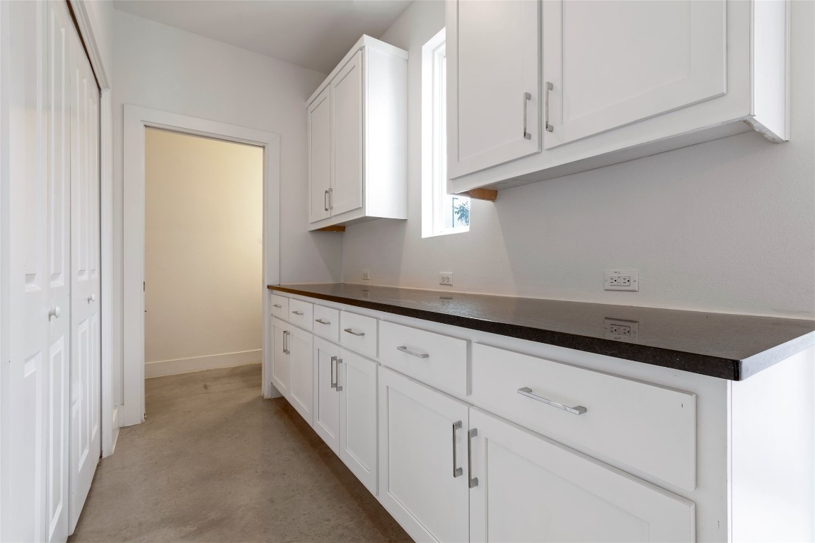1145 Shady Lane, Unit 1A Austin, TX 78721 - Photo 20 of 25 Sleek white kitchen with large island, stainless steel appliances, and pendant lighting.