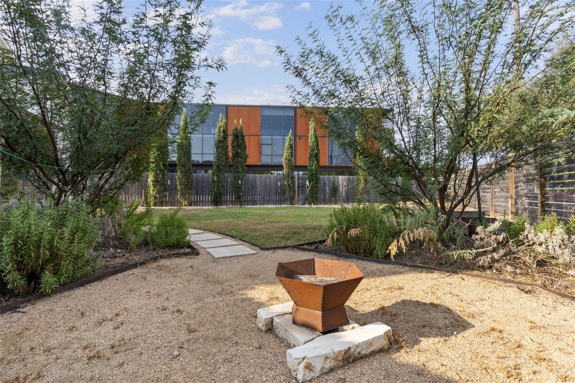 1145 Shady Lane, Unit 1A Austin, TX 78721 - Photo 22 of 25 Backyard & Covered Patio – Rarely found in East Austin, this expansive backyard offers multiple vignettes for entertaining, relaxing, or play. The covered patio creates a natural extension of the living space, surrounded by lush greenery and privacy.