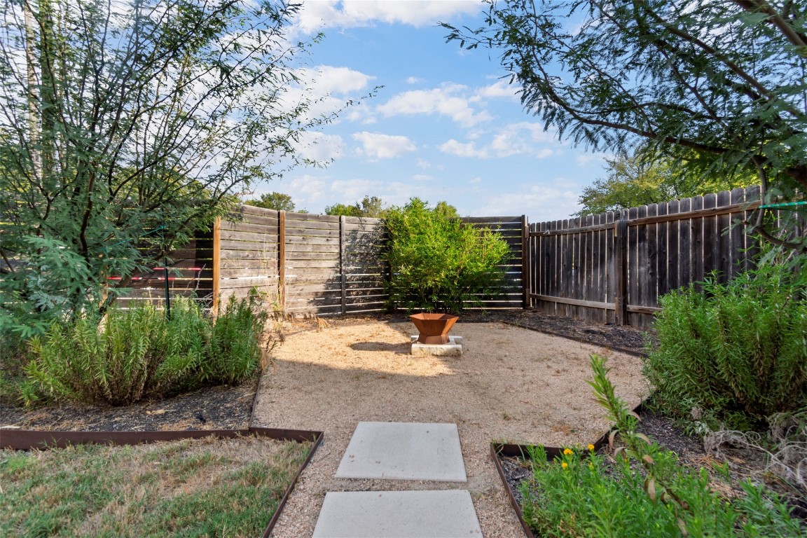 1145 Shady Lane, Unit 1A Austin, TX 78721 - Photo 23 of 25 Backyard & Covered Patio – Rarely found in East Austin, this expansive backyard offers multiple vignettes for entertaining, relaxing, or play. The covered patio creates a natural extension of the living space, surrounded by lush greenery and privacy.