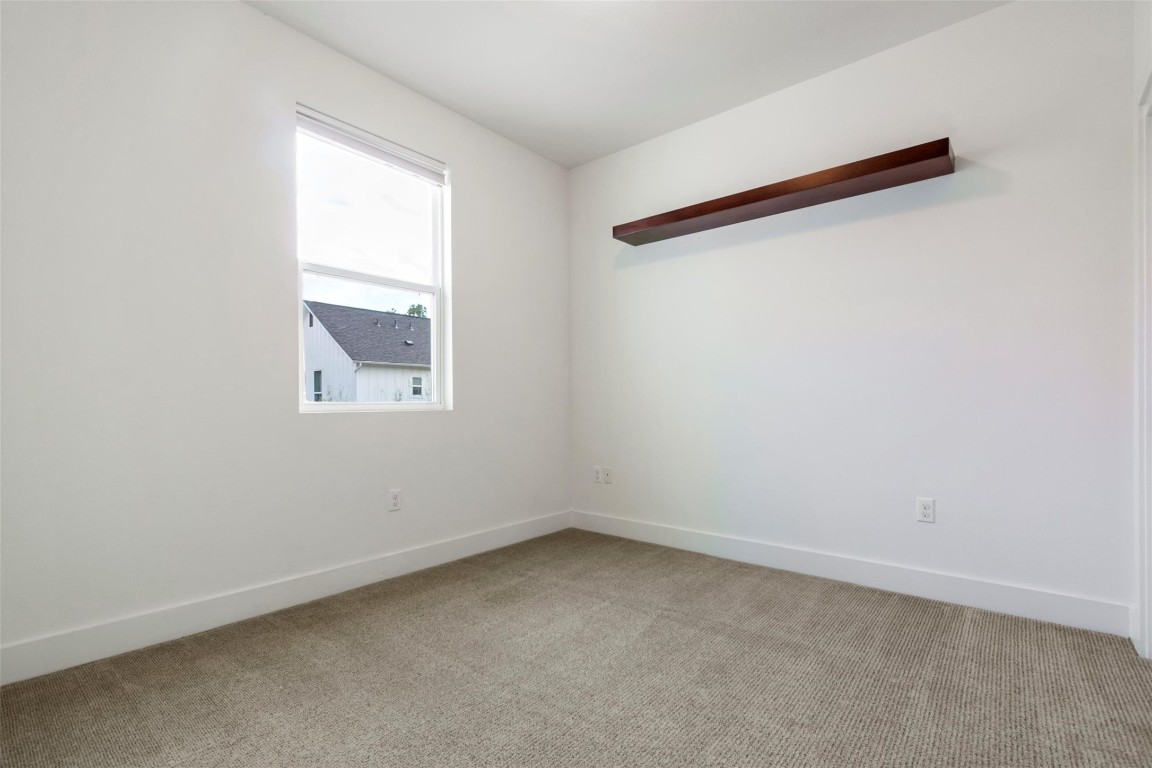 1145 Shady Lane, Unit 1A Austin, TX 78721 - Photo 8 of 25 Guest Bedroom 1 – Versatile guest room or office with neutral design and soft carpet.