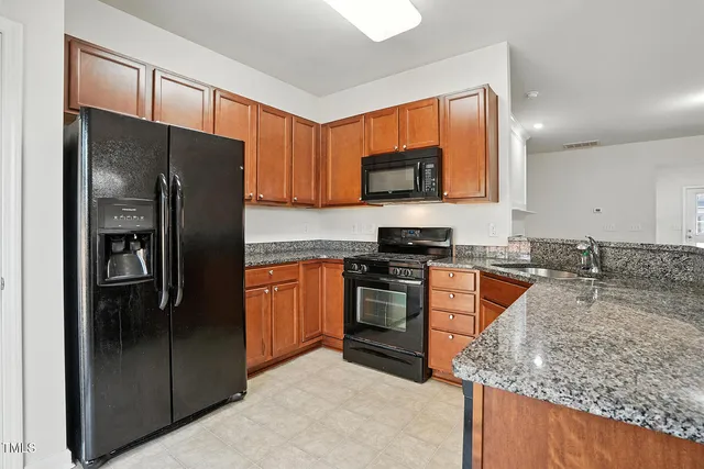 a kitchen with stainless steel appliances granite countertop a refrigerator stove and oven