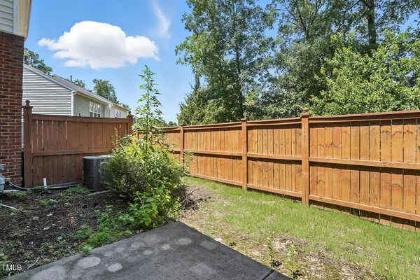 a view of backyard with wooden fence