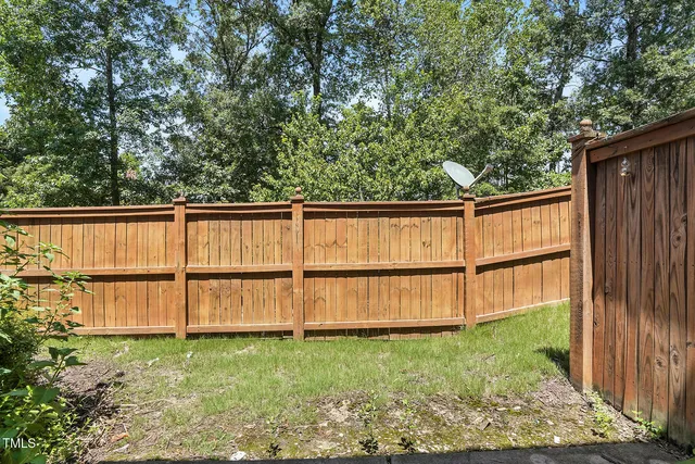 a view of a backyard with wooden fence