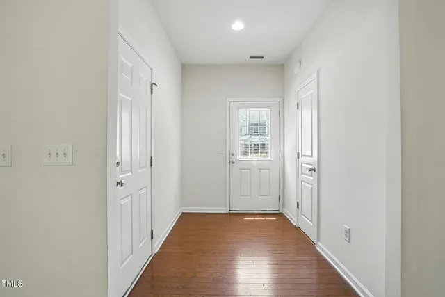 a view of a hallway with wooden floor