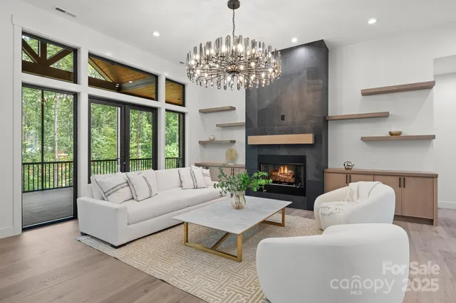 a living room with furniture a chandelier and a fireplace