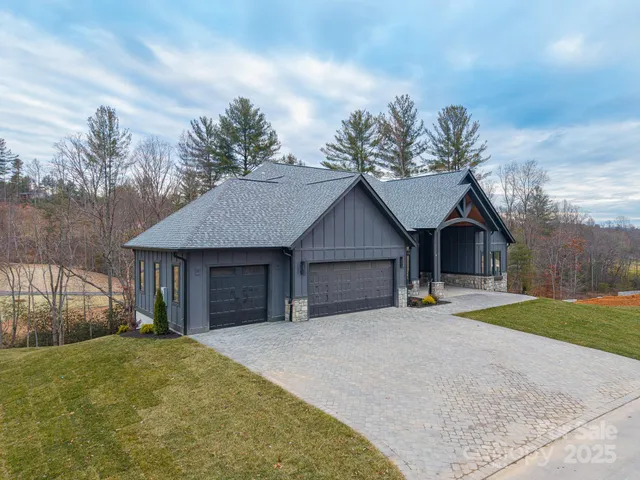 a view of a house with a yard and large tree
