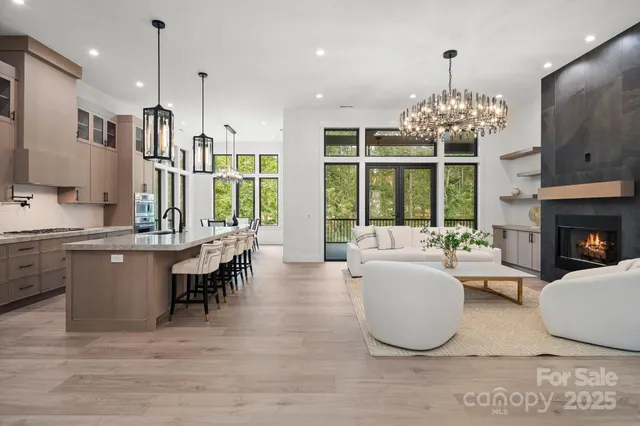 a kitchen with stainless steel appliances granite countertop a table chairs and a refrigerator